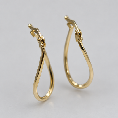 Close up of 9ct gold wavy oval hoop earrings showing hinged snap fitting